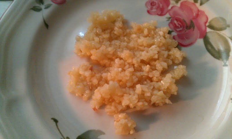 Mound of finely minced garlic on a white plate with a floral rim